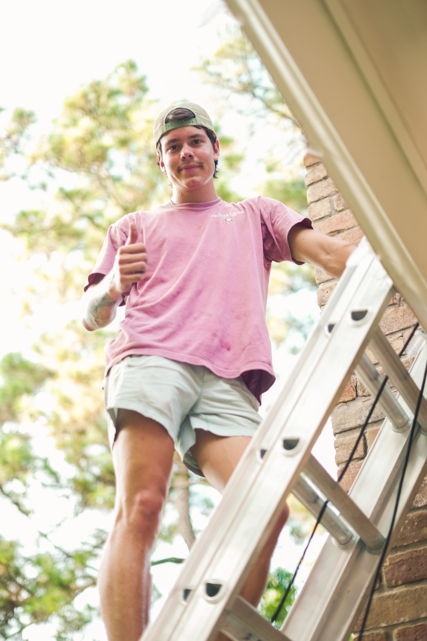 Southern Boys installer on a ladder beside a home